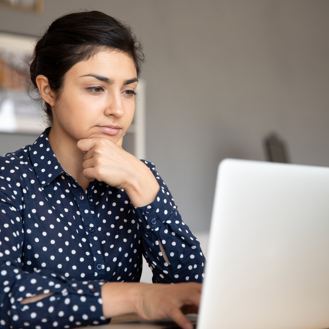 A candidate student using a laptop at a desk.