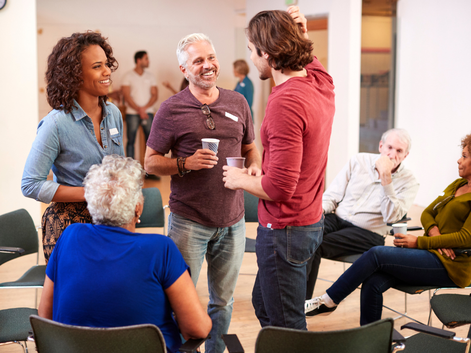 A student talking faculty members during a networking event.