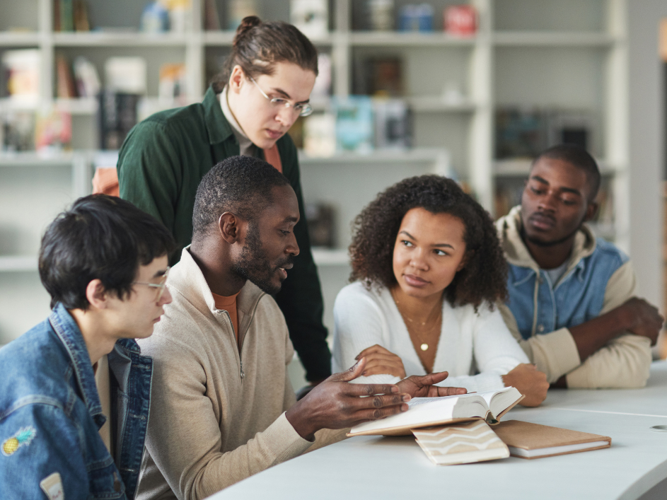 A group of students engaged in conversation while sitting around a table.