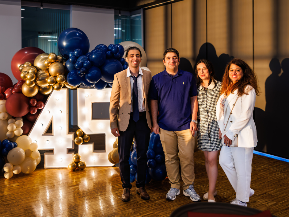 Four DeGroote PhD alumni smiling together at the program's anniversary event.