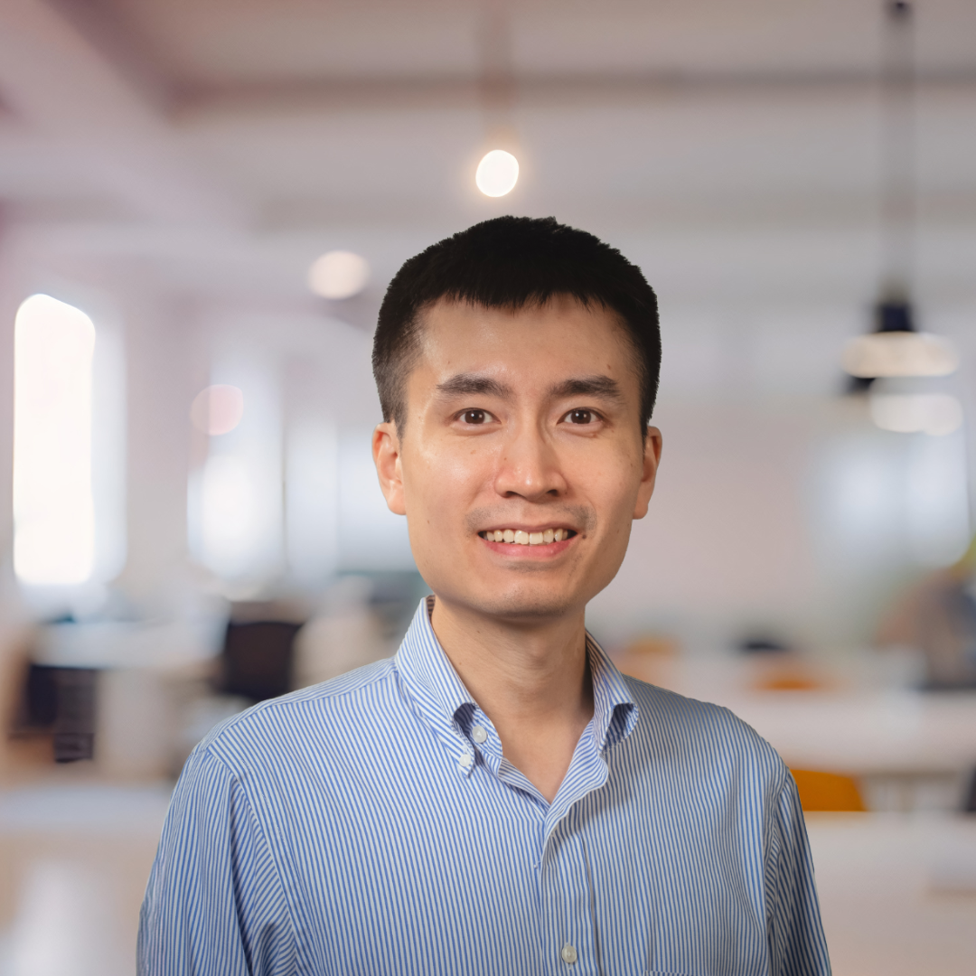 Headshot of Ken Li, a smiling man with short, dark hair, in a blue striped shirt.