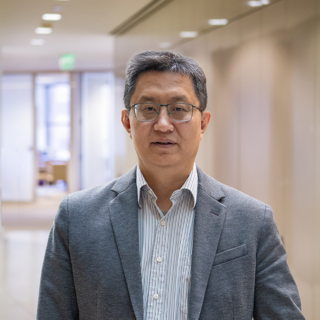 Headshot of Ruhai Wu, a smiling man with short, gray hair, glasses, wearing a grey suit.