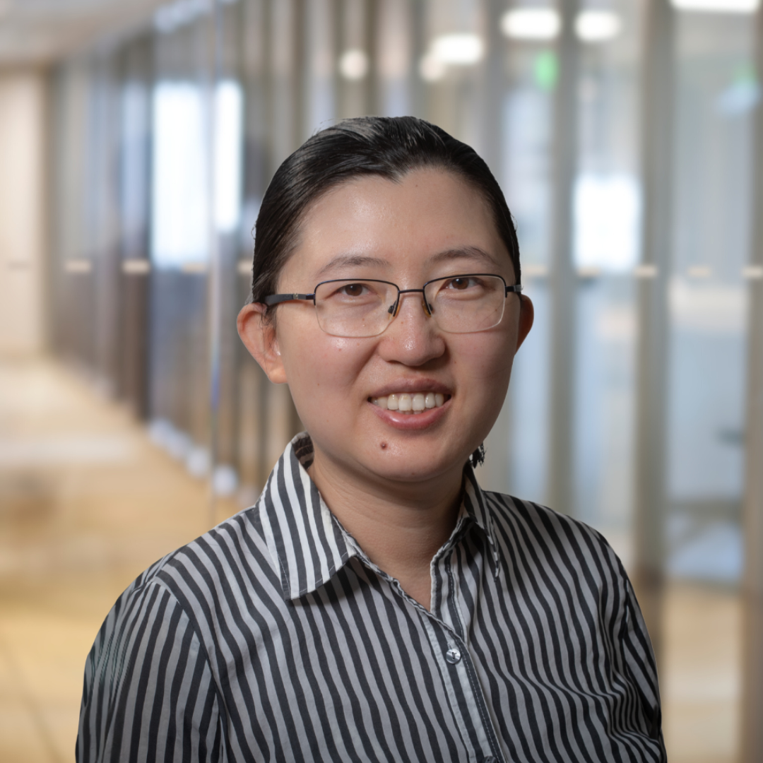 Headshot of Yang Pan, a smiling woman with dark, pulled back hair, glasses wearing a striped shirt.