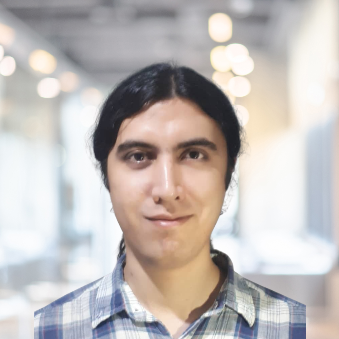 Headshot of Sina Khosravinia, a smiling woman with dark, tied back hair, wearing a blue plaid shirt.