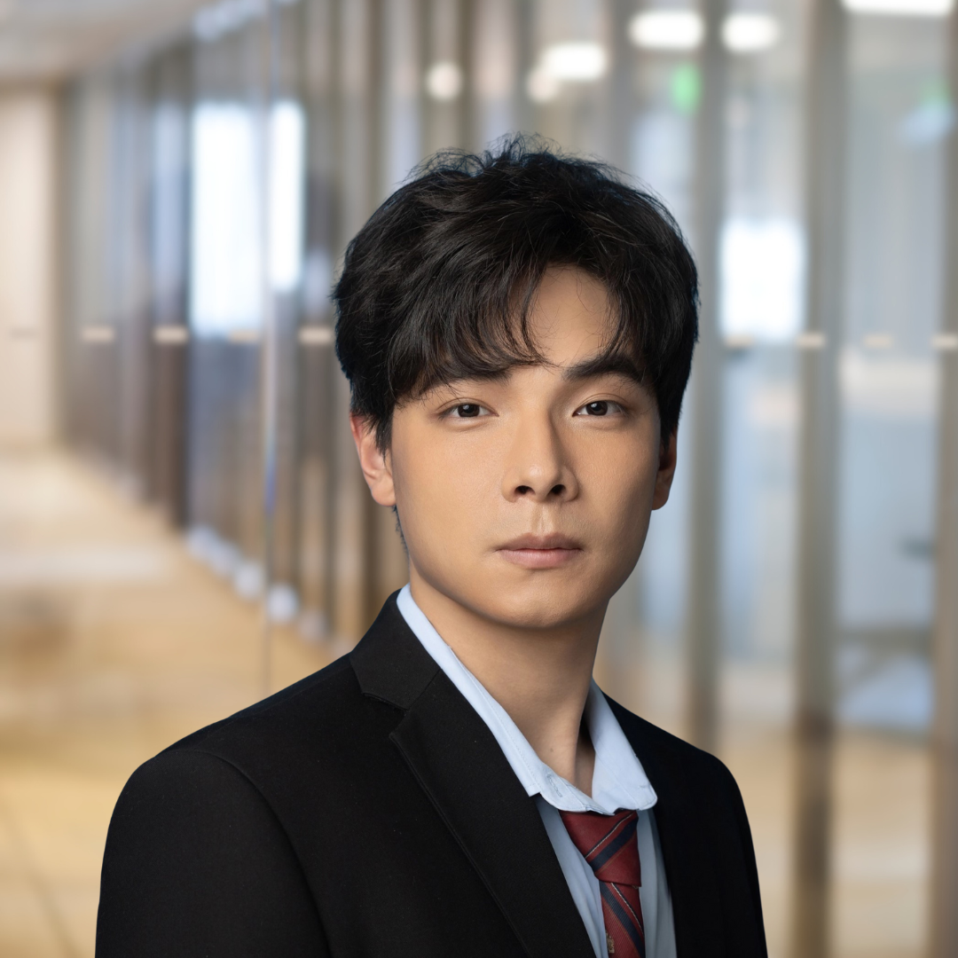 Headshot of Hao Huang, a man with wavy, dark hair, wearing a black suit.